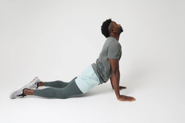 Atletik genç adam gri arka plan üzerinde kas esneme egzersizleri yapıyor. Yüksek kalite fotoğraf, Model.