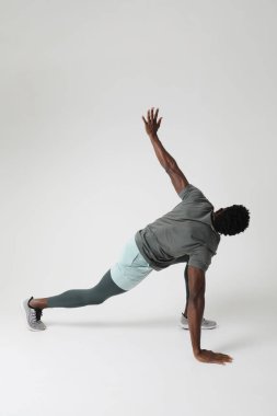 Atletik genç adam içeride kas yoğunluğu egzersizleri yapıyor. Dikey maket. Yüksek kalite fotoğraf.