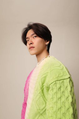 Beyaz arka planda kapalı alanda poz veren kendinden emin bir Asyalı. Yatay maketler. Yüksek kalite fotoğraf.