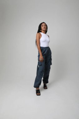 Stüdyoda poz veren uzun siyah örgülü Afro-Amerikalı genç bir kadın. Model-up. Yüksek kalite fotoğraf.