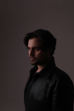 Beyaz duvarda izole edilmiş yakışıklı sakallı adamın yan portresi. Dikey maket. Yüksek kalite fotoğraf.