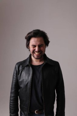 Suratını ekşiten yakışıklı adam beyaz duvarda izole edilmiş. Dikey maket. Yüksek kalite fotoğraf.