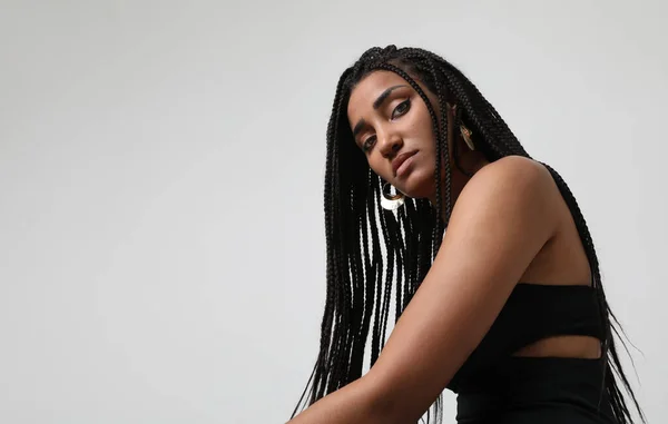 stock image African American young woman with long dark braids, posing at studio. Mock-up. High quality photo.