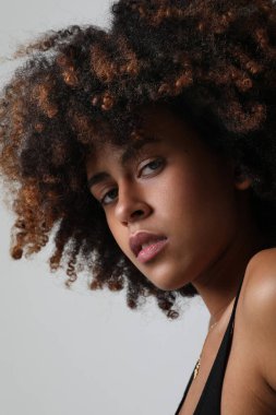 Beautiful African American woman looking at camera. Portrait of cheerful young woman with afro hairstyle. Beauty girl with curly hair. High quality photo