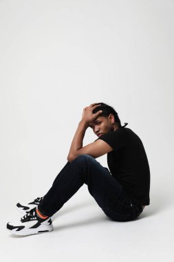 Stüdyoda poz veren yorgun ve stresli koyu tenli genç adam. Dikey. Yüksek kalite fotoğraf.