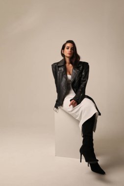 Stüdyoda motosiklet ceketi giymiş güzel bir genç kadın. Dikey maket. Yüksek kalite fotoğraf.