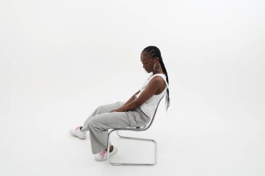 Beyaz duvarda poz veren uzun örgülü Afrikalı genç bir kadının yan portresi. - Evet. Yüksek kalite fotoğraf.