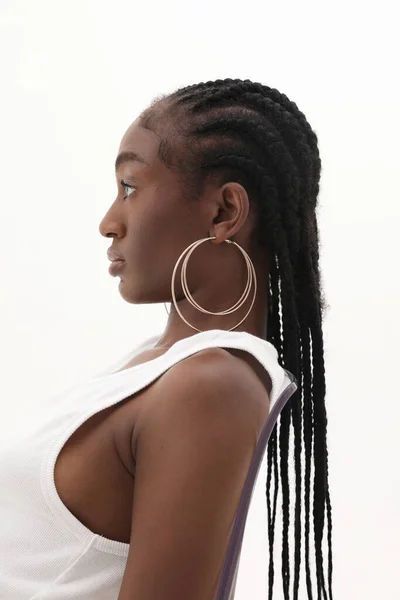 非洲年轻女子的侧面肖像 长长的辫子 头戴金黄色的圈圈 装模作样 高质量的照片 — 图库照片
