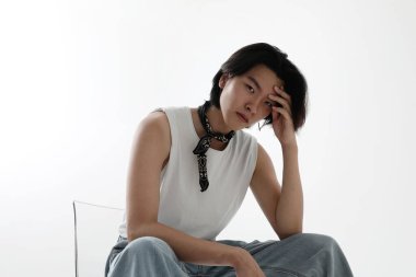 Beyaz arka planda kapalı alanda poz veren kendinden emin bir Asyalı. Dikey maket. Yüksek kalite fotoğraf.