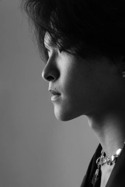 İçeride poz veren kendine güvenen yakışıklı Asyalı adamın dikey yakın çekimi. Siyah ve beyaz. Yüksek kalite fotoğraf.