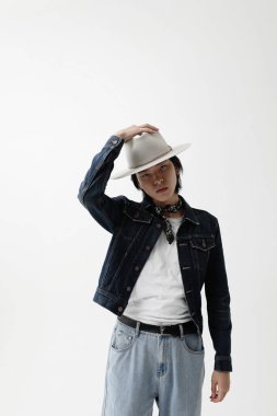 Beyaz duvarın üzerinden içeri poz veren kendine güvenen yakışıklı Asyalı adam. Dikey. Yüksek kalite fotoğraf.