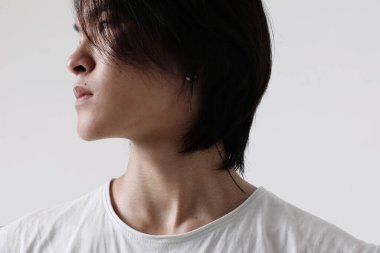 Beyaz arka planda kapalı alanda poz veren kendinden emin bir Asyalı. Model-up. Yüksek kalite fotoğraf.