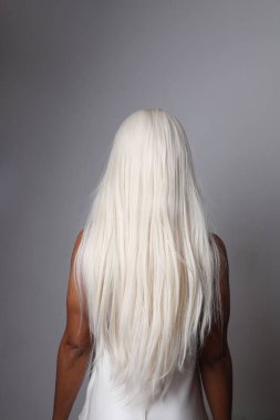 Uzun sarı saçlı bir kadının dikey portresi. Kapalı alanda poz vermek. Yüksek kalite fotoğraf.