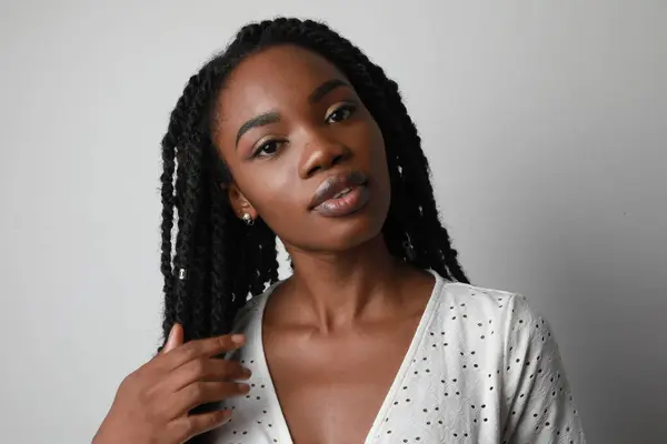 stock image Smiling attractive young African woman with long braids posing over white wall. High quality photo.