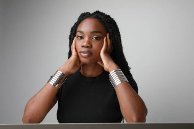 Uzun örgülü üzgün ve yorgun bir Afrikalı Amerikalı kadın. Yatay olarak. Yüksek kalite fotoğraf.