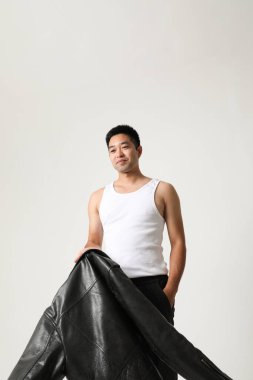 Yüzünde iyimser bir ifade olan yakışıklı bir Asyalının portresi. Dikey. Yüksek kalite fotoğraf.