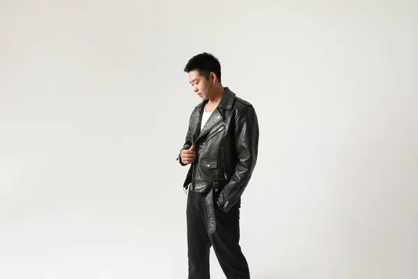 一个年轻英俊的亚洲人穿着皮夹克在室内摆姿势的画像 高质量的照片 — 图库照片#