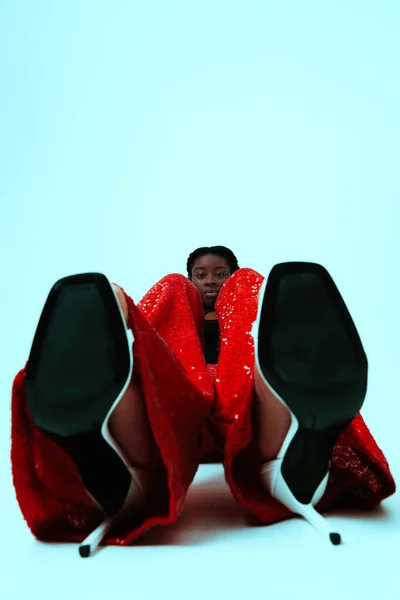 年轻的非洲女人穿着红色的裤子 坐在蓝色的背景上 高质量的照片 — 图库照片
