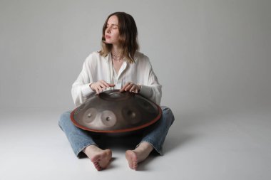 Güzel, genç bir kadın, içeride davul çalarak rahatlatıcı bir müzik çalar. Yüksek kalite fotoğraf.