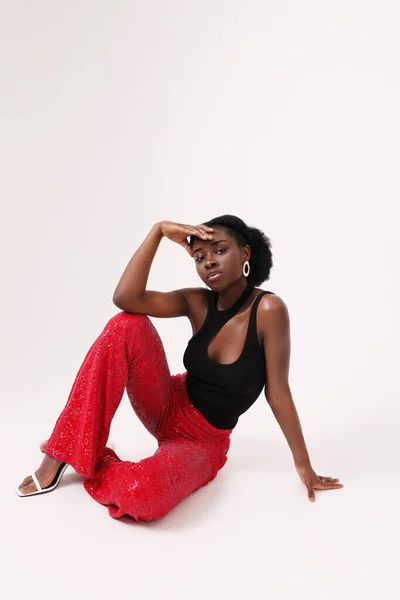 年轻的非洲女人自信地穿着红色裤子 摆出一副白色背景的样子 高质量的照片 — 图库照片