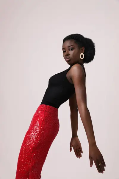 年轻的非洲女人穿着红色裤子 摆出白色背景的样子 垂直的 高质量的照片 — 图库照片