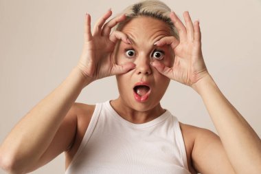 Beyaz arka planda yüzünü buruşturan duygusal kadının stüdyo portresi. Yüksek kalite fotoğraf.