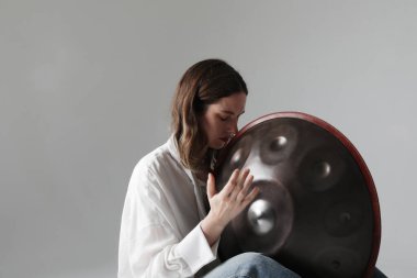 Kadın, davul tokmağı ile gevşetici müzik çalıyor ve içeride poz veriyor. Yatay olarak. Yüksek kalite fotoğraf.