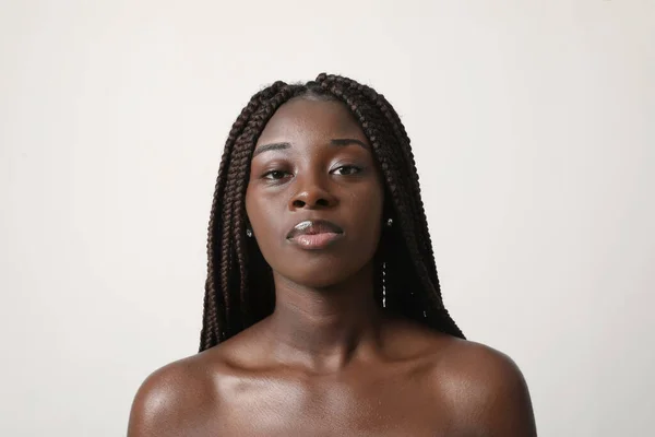 年轻的非洲裔美国女人自信地看着相机 其简单的表情揭示了她在白色背景下的思考和沉思的深度 — 图库照片