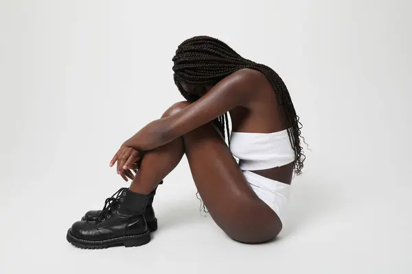一个有着长长的辫子的富有沉思和悲伤的非洲裔美国女人在室内摆姿势 高质量的照片 — 图库照片