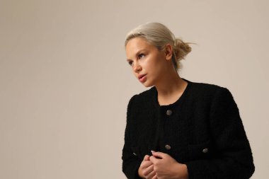 Beyaz duvarda poz veren güzel sarışın genç bir kadının portresi. Yüksek kalite fotoğraf.