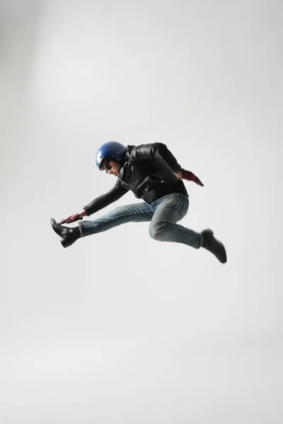 Potret Vertikal Pemuda Mengenakan Helm Dan Jaket Hitam Melompat Dalam Stok Foto