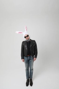 Beyaz arka planda tavşan kulağı takan duygusal sakallı bir adam. İzole edilmiş. Yüksek kalite fotoğraf.