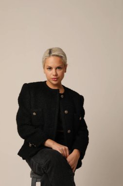 Beyaz duvarda poz veren güzel sarışın genç bir kadının portresi. Yüksek kalite fotoğraf. Dikey.