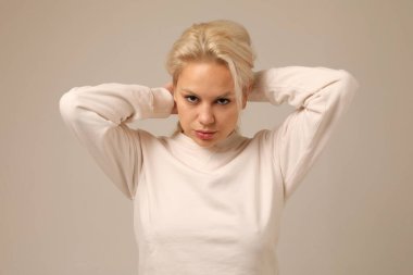 Beyaz duvarda poz veren ve başka tarafa bakan çalışan genç bir kadının portresi. İzole edilmiş. Yüksek kalite fotoğraf.