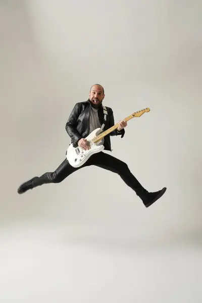Musisi Rock Seorang Pria Dengan Gitar Putih Melompat Dan Berpose — Stok Foto