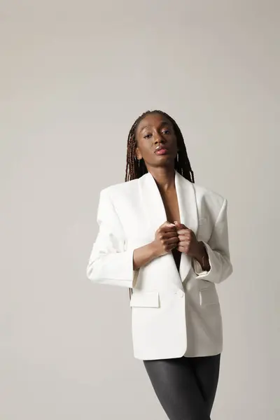 Vakker Afroamerikansk Kvinne Bærer Hvit Blazer Som Poserer Grå Bakgrunn stockbilde