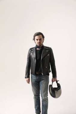 Kasklı ve siyah ceketli sakallı bir adam içeride poz veriyor. Model-up. Yüksek kalite fotoğraf.