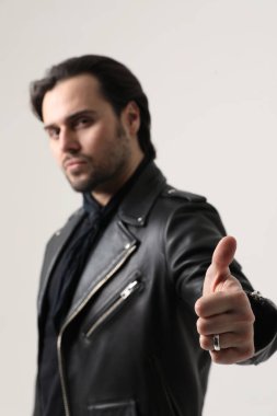 Kasklı ve siyah ceketli sakallı bir adam içeride poz veriyor. Model-up. Yüksek kalite fotoğraf.