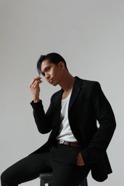 Beyaz arka planda poz veren düşünceli Asyalı bir adamın portresi. Dikey. Yüksek kalite fotoğraf.
