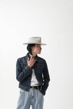 Beyaz arka planda kapalı alanda poz veren, kendine güvenen Asyalı yakışıklı bir adam. Yüksek kalite fotoğraf.