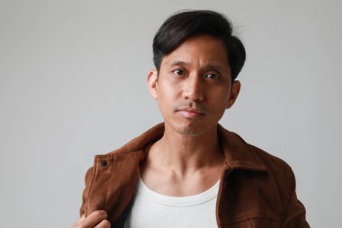 Beyaz arka planda poz verip kameraya bakan Asyalı adamın portresi. Yüksek kalite fotoğraf