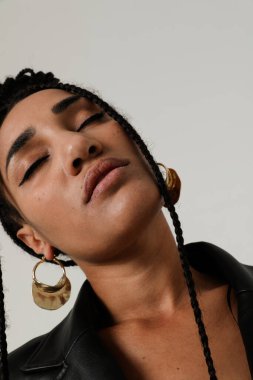 İçeride poz veren uzun siyah örgülü Afro-Amerikan genç kadın portresi. Dikey. Yüksek kalite fotoğraf.