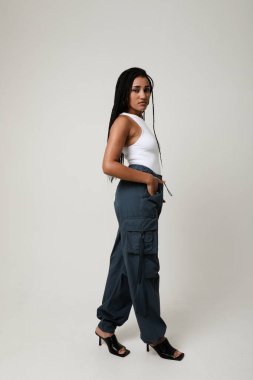 İçeride poz veren uzun siyah örgülü Afro-Amerikan genç kadın portresi. Dikey. Yüksek kalite fotoğraf.