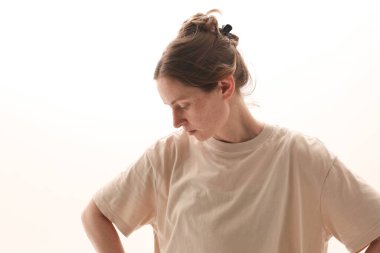 Beautiful young woman wearing casual t-shit looking away and posing indoor. . High quality photo.