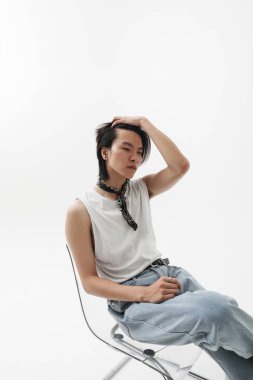 Yakışıklı ve genç Asyalı bir adam beyaz arka planda iç mekan pozu veriyor. Model-up. Yüksek kalite fotoğraf.