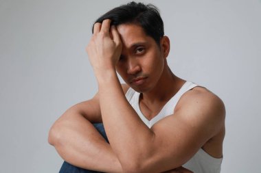 Kameraya bakarak beyaz arka planda poz veren Asyalı ciddi bir adamın portresi. Yüksek kalite fotoğraf.