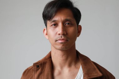 Beyaz arka planda poz verip kameraya bakan yakışıklı Asyalı adamın portresi. Yüksek kalite fotoğraf.