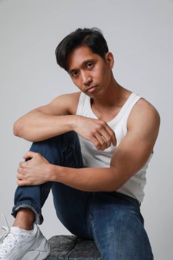 Beyaz arka planda poz verip kameraya bakan yakışıklı Asyalı adamın portresi. Yüksek kalite fotoğraf.