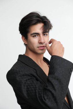 Beyaz arka planda poz veren yakışıklı bir gencin portresi. Dikey. Yüksek kalite fotoğraf.