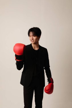 Beyaz arka planda duran kırmızı eldivenli kendinden emin Asyalı genç adam. Akıl sağlığı sorunları. Yüksek kalite fotoğraf.